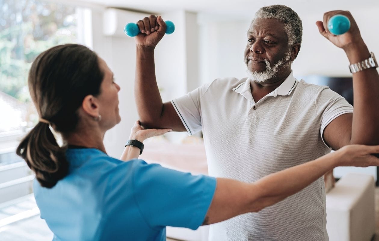 A physio assisting an elderly male